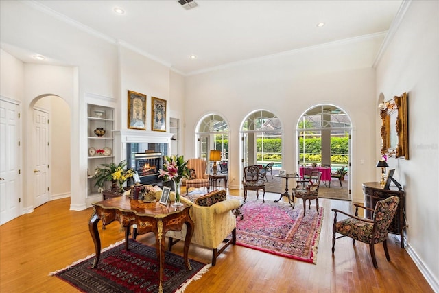 living room with ornamental molding, hardwood / wood-style floors, and a high ceiling