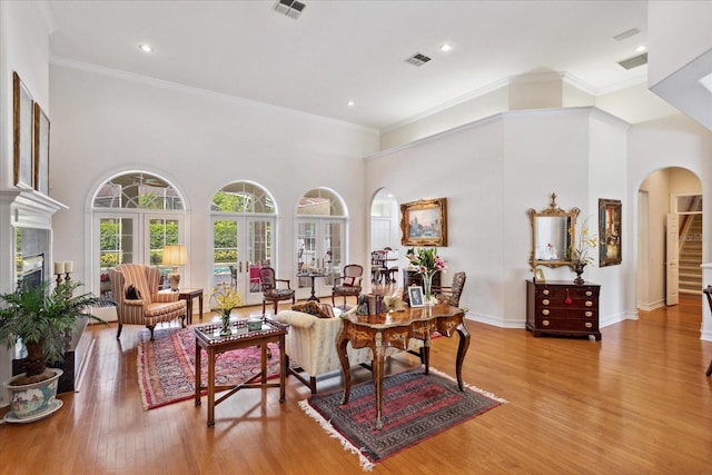 interior space with a high ceiling, light hardwood / wood-style flooring, and crown molding