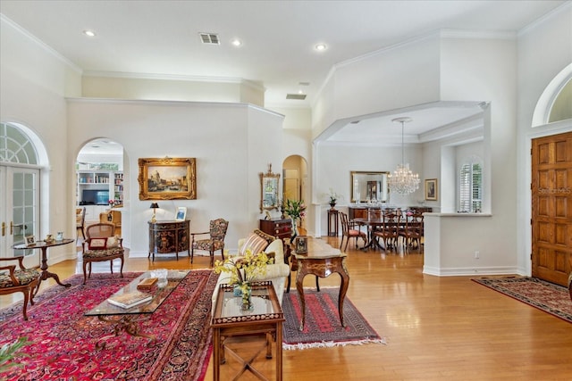 interior space featuring a chandelier, crown molding, light hardwood / wood-style flooring, and plenty of natural light