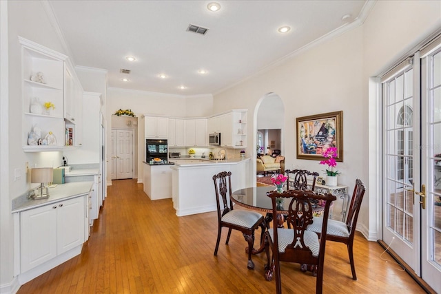 dining space with light hardwood / wood-style flooring and ornamental molding