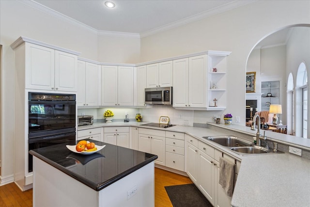 kitchen featuring sink, black appliances, and white cabinetry