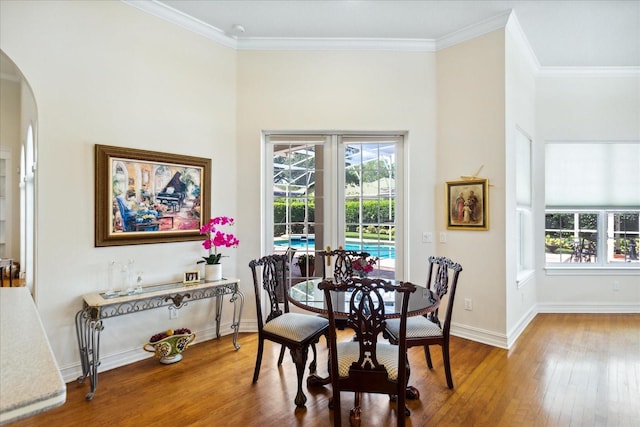 dining space with french doors, crown molding, and wood-type flooring