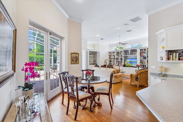 dining room with crown molding, light hardwood / wood-style flooring, and ceiling fan