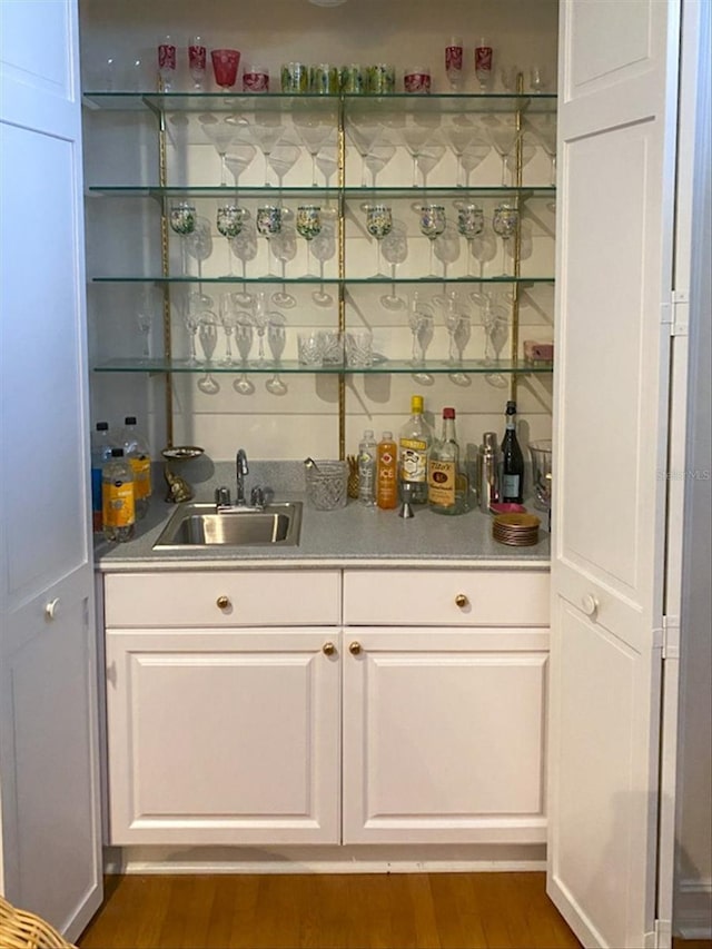 bar featuring white cabinetry, sink, and dark hardwood / wood-style flooring