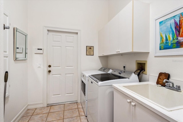 clothes washing area with cabinets, washer and dryer, sink, and light tile patterned floors