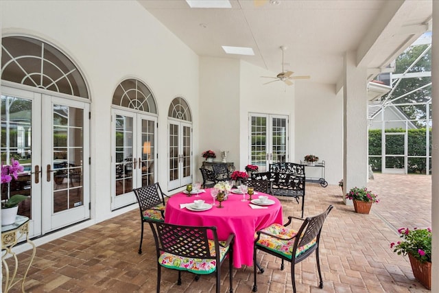 view of patio featuring french doors, ceiling fan, and glass enclosure