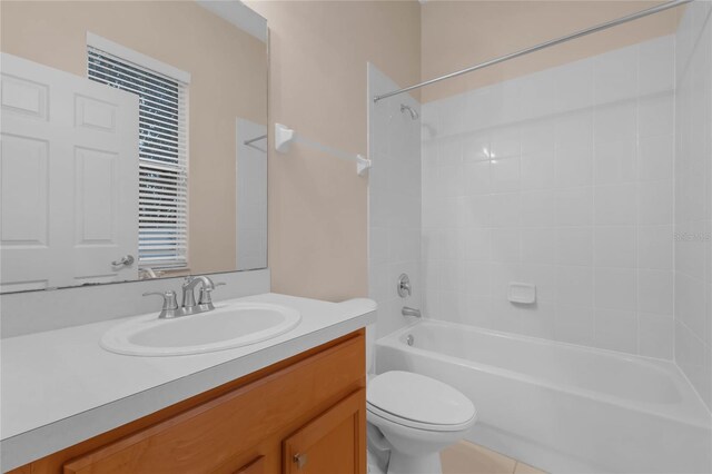 full bathroom with tiled shower / bath, vanity, and toilet