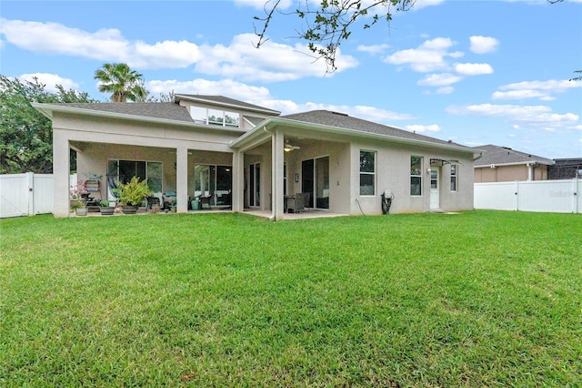 back of property with a lawn and a patio area