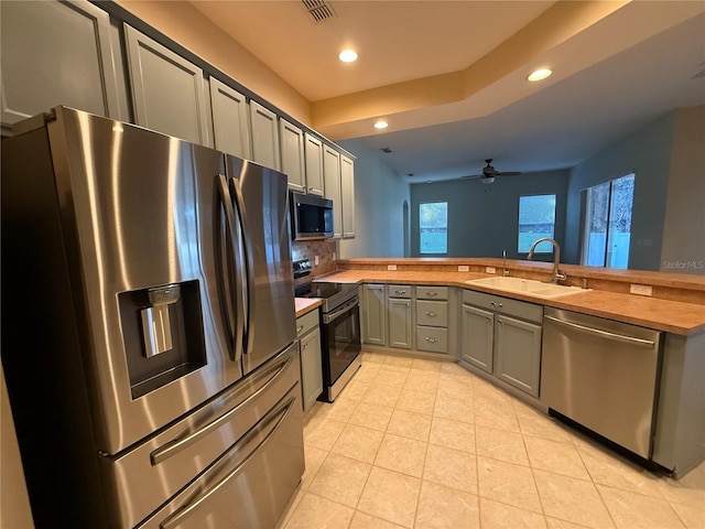 kitchen featuring sink, light tile patterned floors, gray cabinets, appliances with stainless steel finishes, and butcher block counters