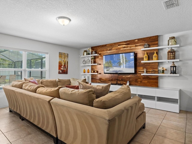 living room featuring light tile flooring, a textured ceiling, and wooden walls