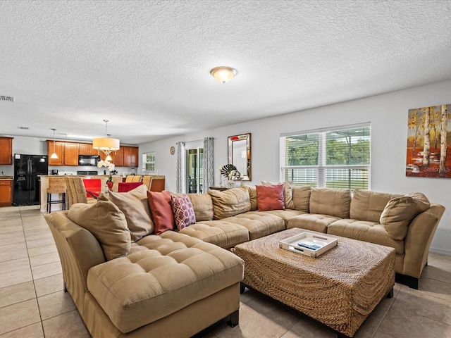 living room featuring a textured ceiling and light tile floors