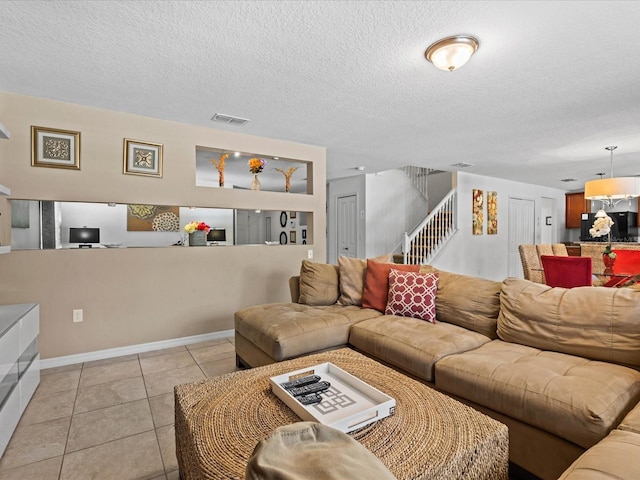 living room with a textured ceiling and light tile floors