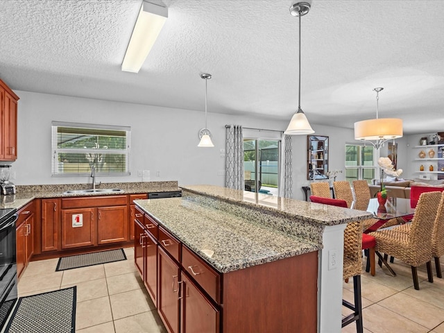 kitchen with hanging light fixtures, a healthy amount of sunlight, and light tile flooring