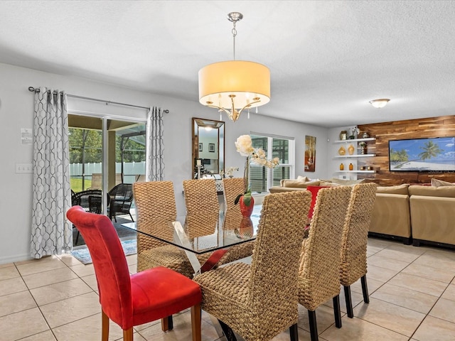 tiled dining room featuring a notable chandelier and a textured ceiling