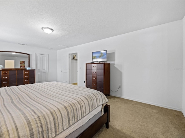 carpeted bedroom featuring a closet and a textured ceiling