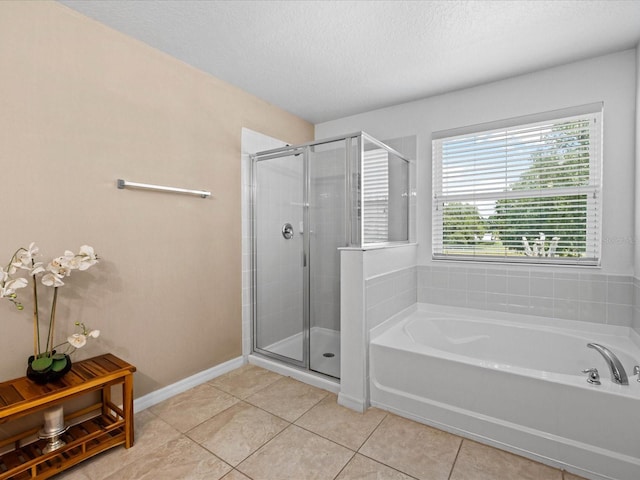 bathroom with tile flooring, shower with separate bathtub, and a textured ceiling