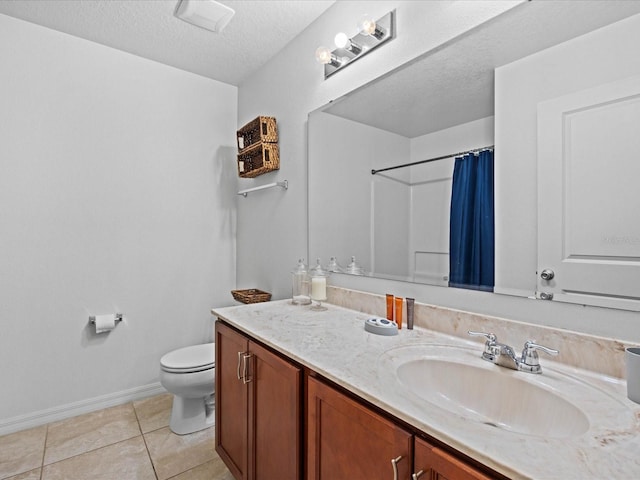 bathroom featuring tile flooring, vanity, toilet, and a textured ceiling