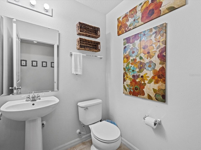 bathroom with tile flooring, a textured ceiling, and toilet