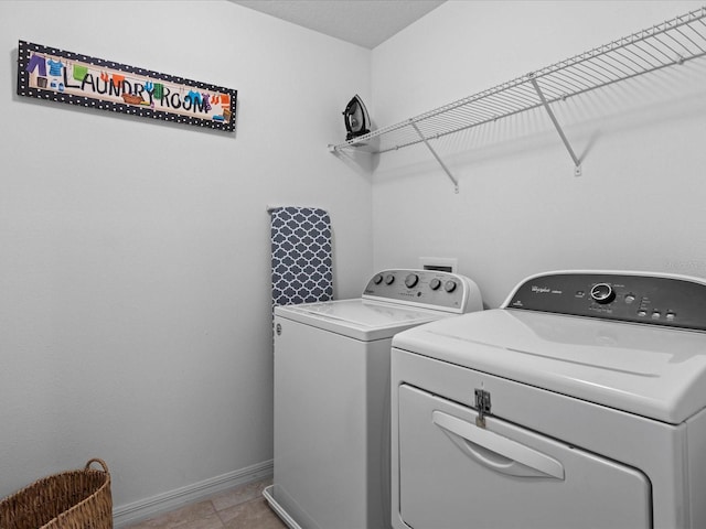 washroom with washer and dryer and light tile floors