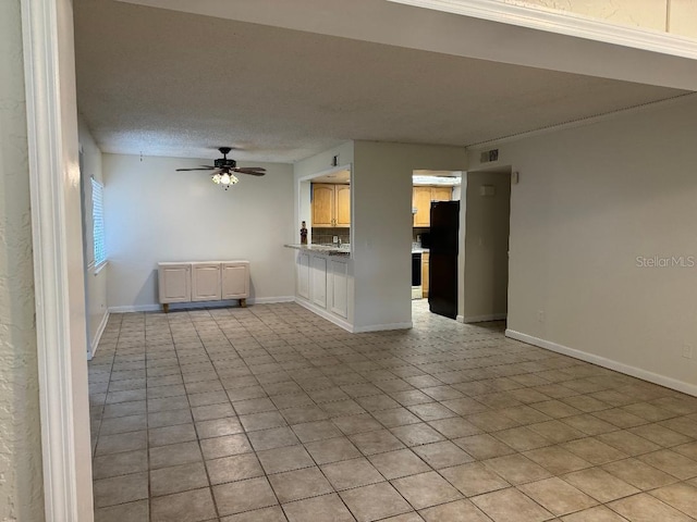 tiled spare room featuring ceiling fan, a textured ceiling, and sink