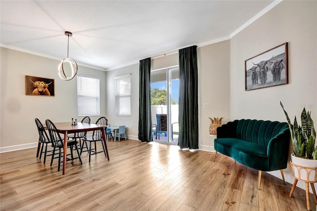 dining room featuring a healthy amount of sunlight, crown molding, and light wood-type flooring