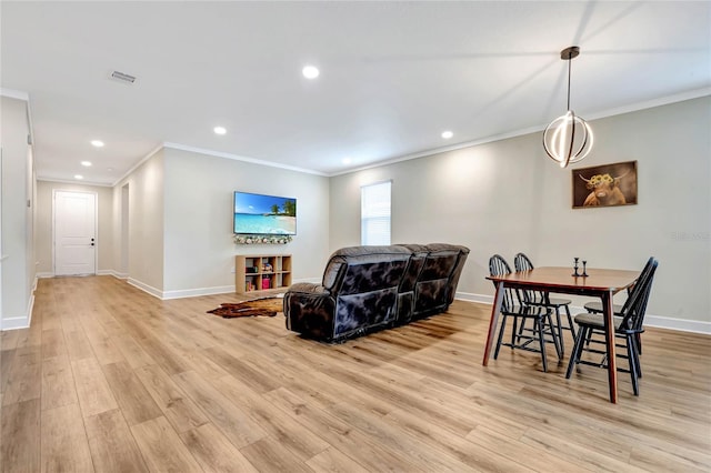 dining room with light hardwood / wood-style floors and crown molding