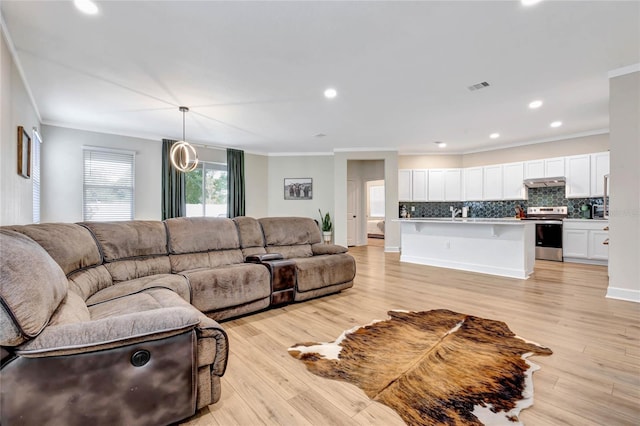 living room featuring ornamental molding and light hardwood / wood-style floors