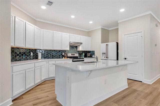 kitchen with light wood-type flooring, an island with sink, electric range, high end white refrigerator, and backsplash