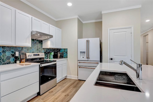 kitchen featuring white cabinetry, electric stove, high end white refrigerator, and wall chimney exhaust hood