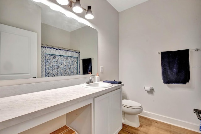 bathroom featuring toilet, hardwood / wood-style flooring, and large vanity