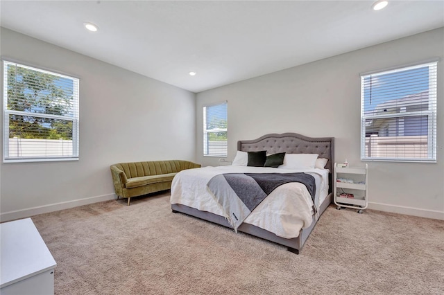 bedroom with multiple windows and light colored carpet