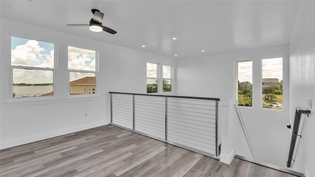 interior space with light hardwood / wood-style flooring, a wealth of natural light, and ceiling fan