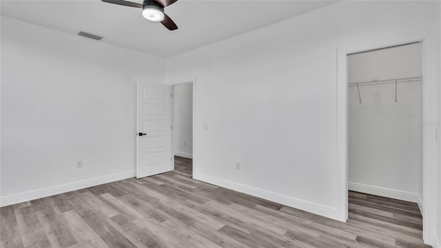 unfurnished bedroom featuring ceiling fan, hardwood / wood-style floors, and a closet