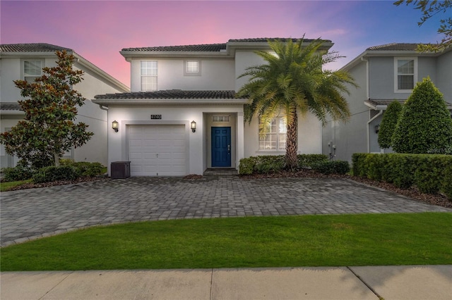 mediterranean / spanish-style house with a garage and a yard