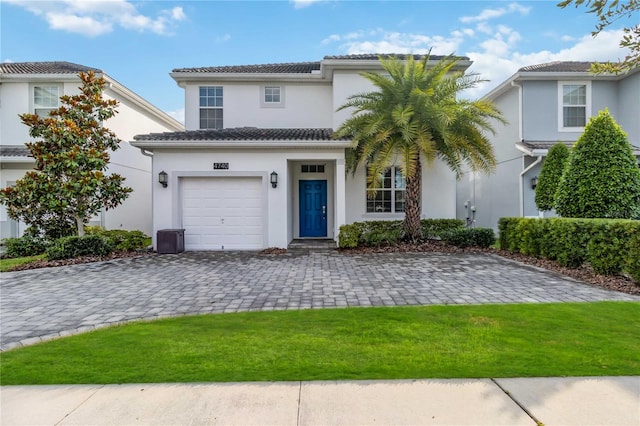 mediterranean / spanish-style home featuring a garage and a front lawn