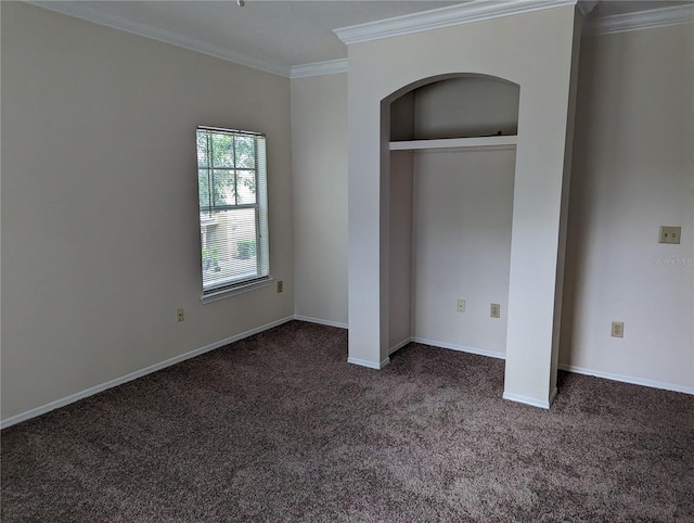 unfurnished bedroom with dark carpet and crown molding