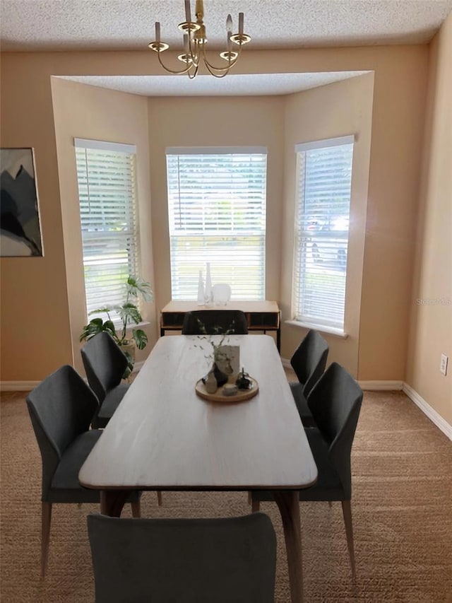 carpeted dining room with an inviting chandelier and a textured ceiling