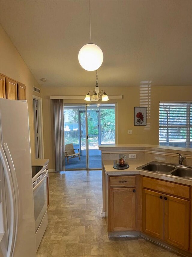 kitchen with sink, range, light tile flooring, and pendant lighting