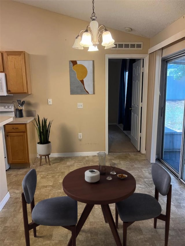 dining area with lofted ceiling and a chandelier