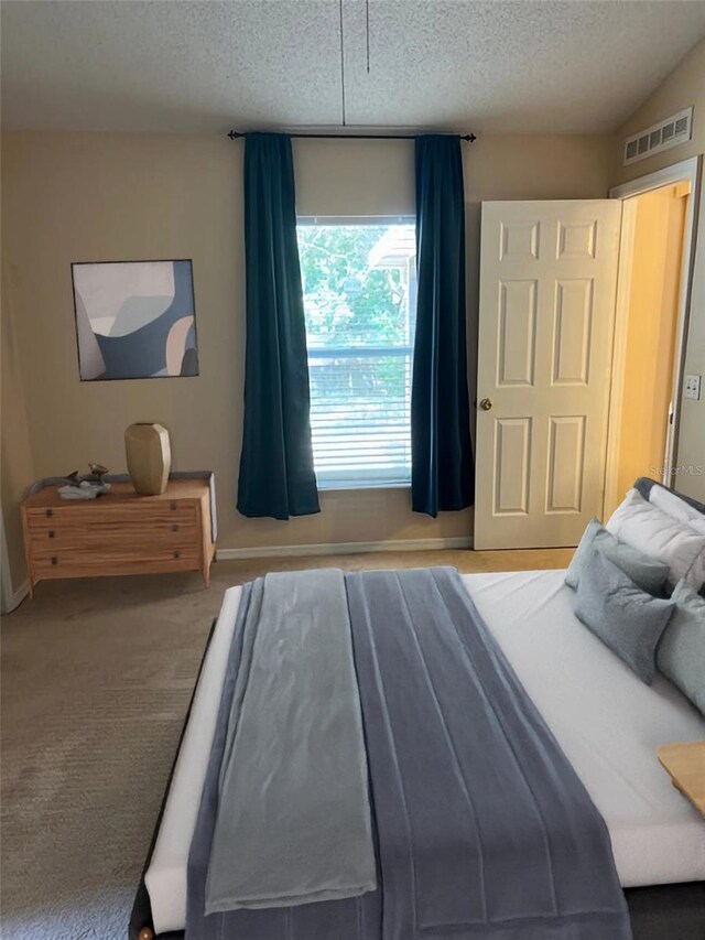 carpeted bedroom featuring a textured ceiling