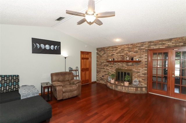 living room with ceiling fan, dark hardwood / wood-style floors, a textured ceiling, lofted ceiling, and a fireplace