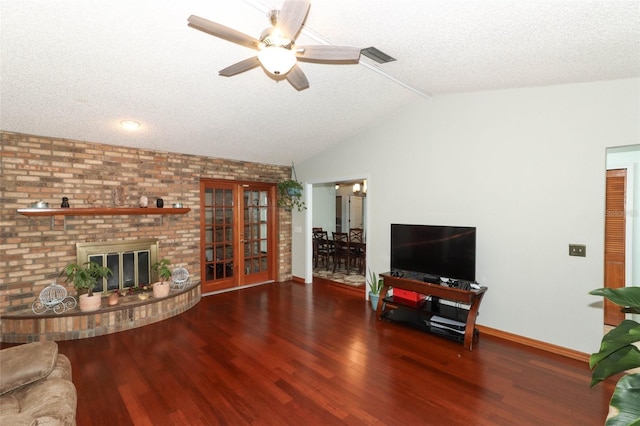 living room with a brick fireplace, a textured ceiling, vaulted ceiling, ceiling fan, and dark hardwood / wood-style floors