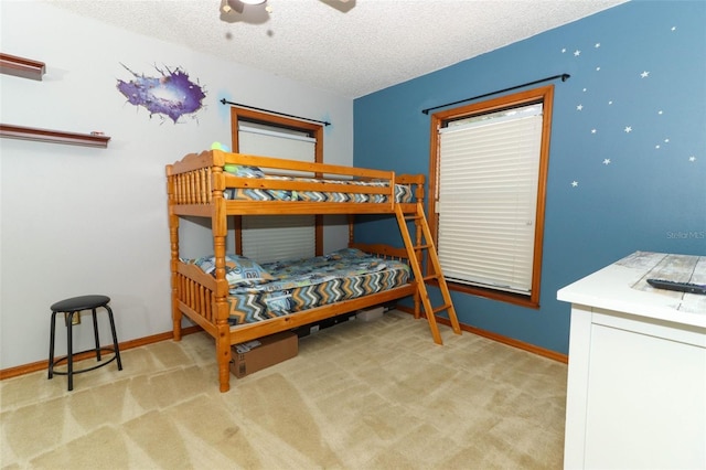 carpeted bedroom featuring ceiling fan and a textured ceiling