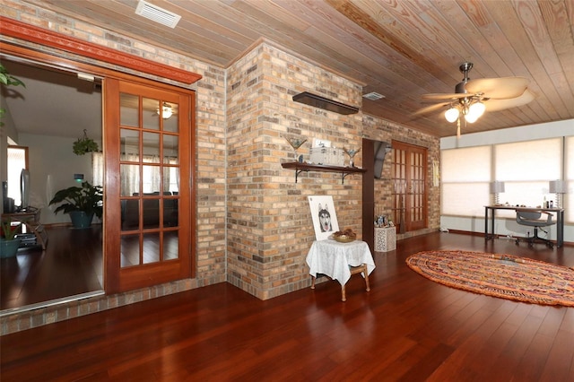 sitting room with hardwood / wood-style floors, wood ceiling, brick wall, and french doors