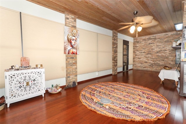 living area with wood ceiling, ceiling fan, hardwood / wood-style floors, and brick wall