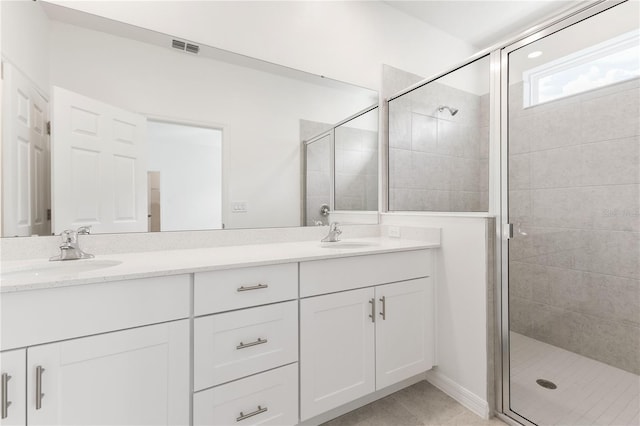 bathroom featuring walk in shower, vanity, and tile patterned flooring