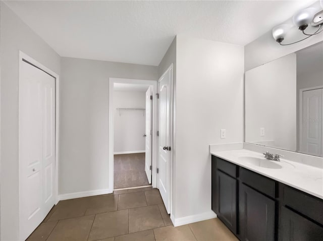 bathroom with a textured ceiling, vanity, and tile patterned floors