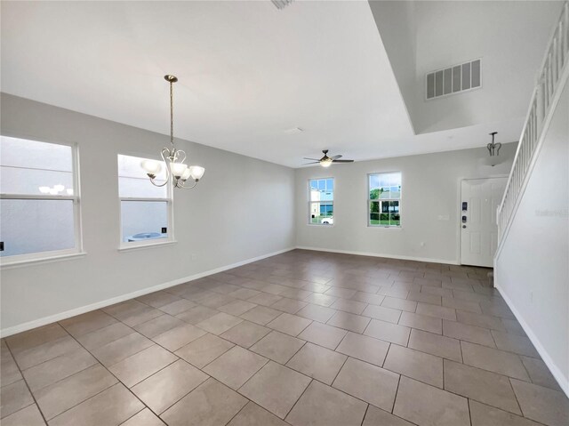 empty room featuring ceiling fan with notable chandelier and light tile patterned floors