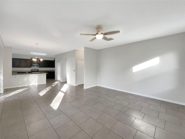 unfurnished living room with tile patterned flooring, ceiling fan with notable chandelier, and sink