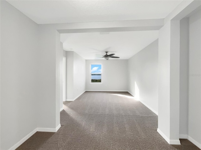 empty room with ceiling fan and dark carpet